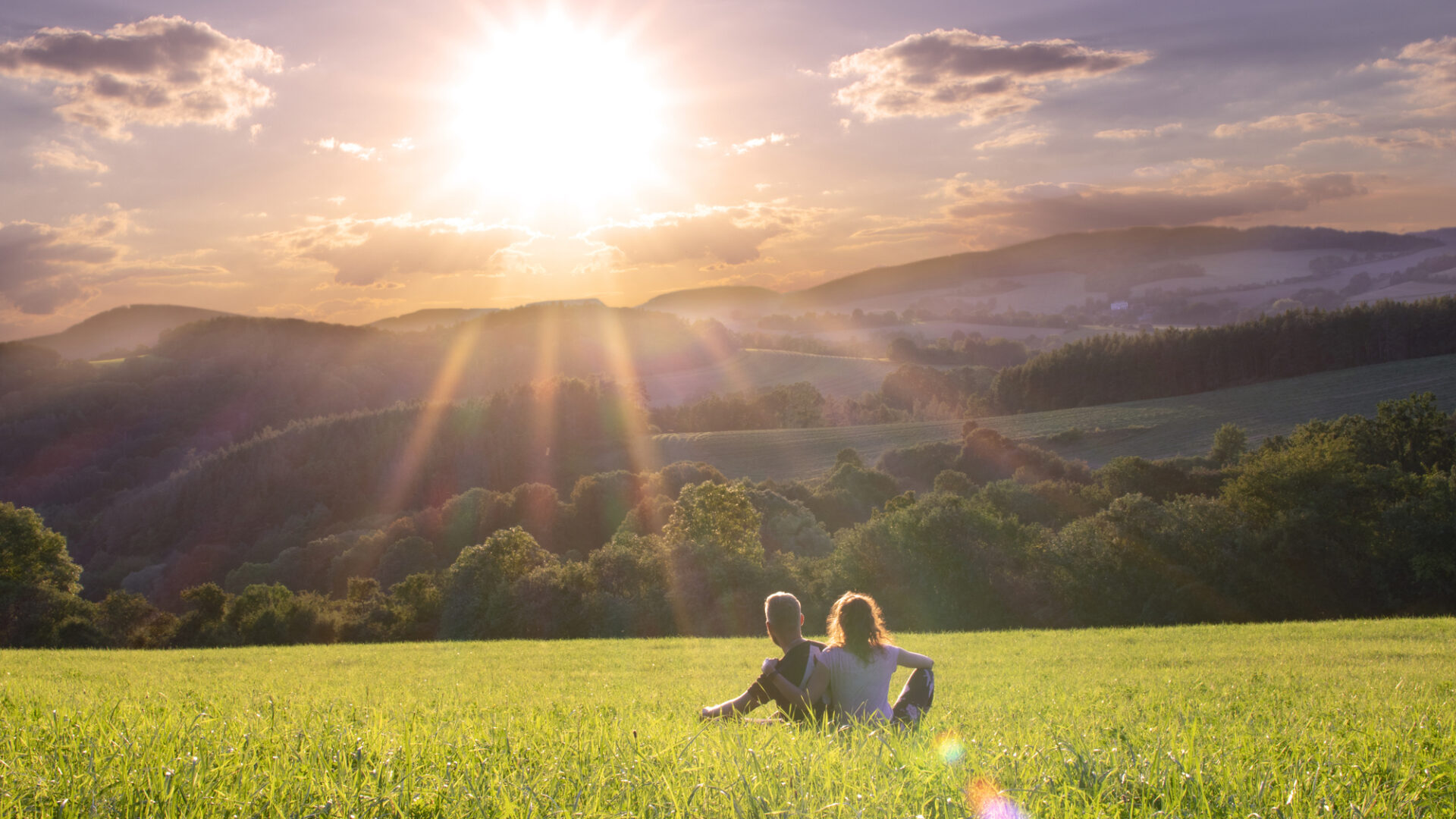 two-people-in-grass-at-sunrise