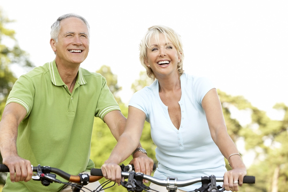 happy senior couple riding bikes